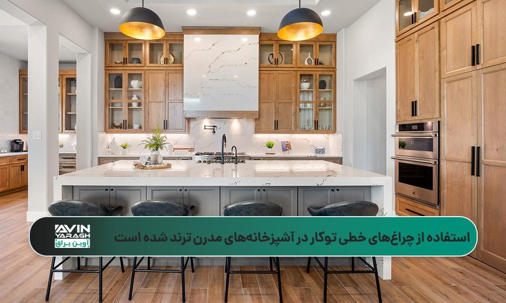 آشپزخانهای با جزیره مرمر سفید، کابینتهای چوبی با درهای شیشهای و نورپردازی خطی