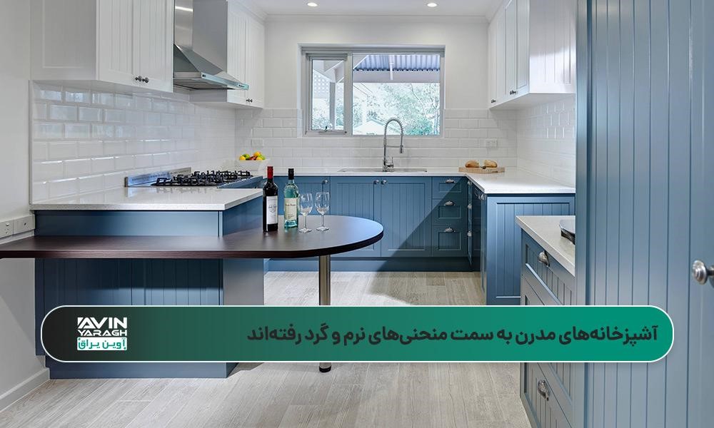 آشپزخانهای مدرن با کابینتهای آبی ملایم، کاشیهای بینکابینتی سفید و کانتر چوبی نیمدایرهای
